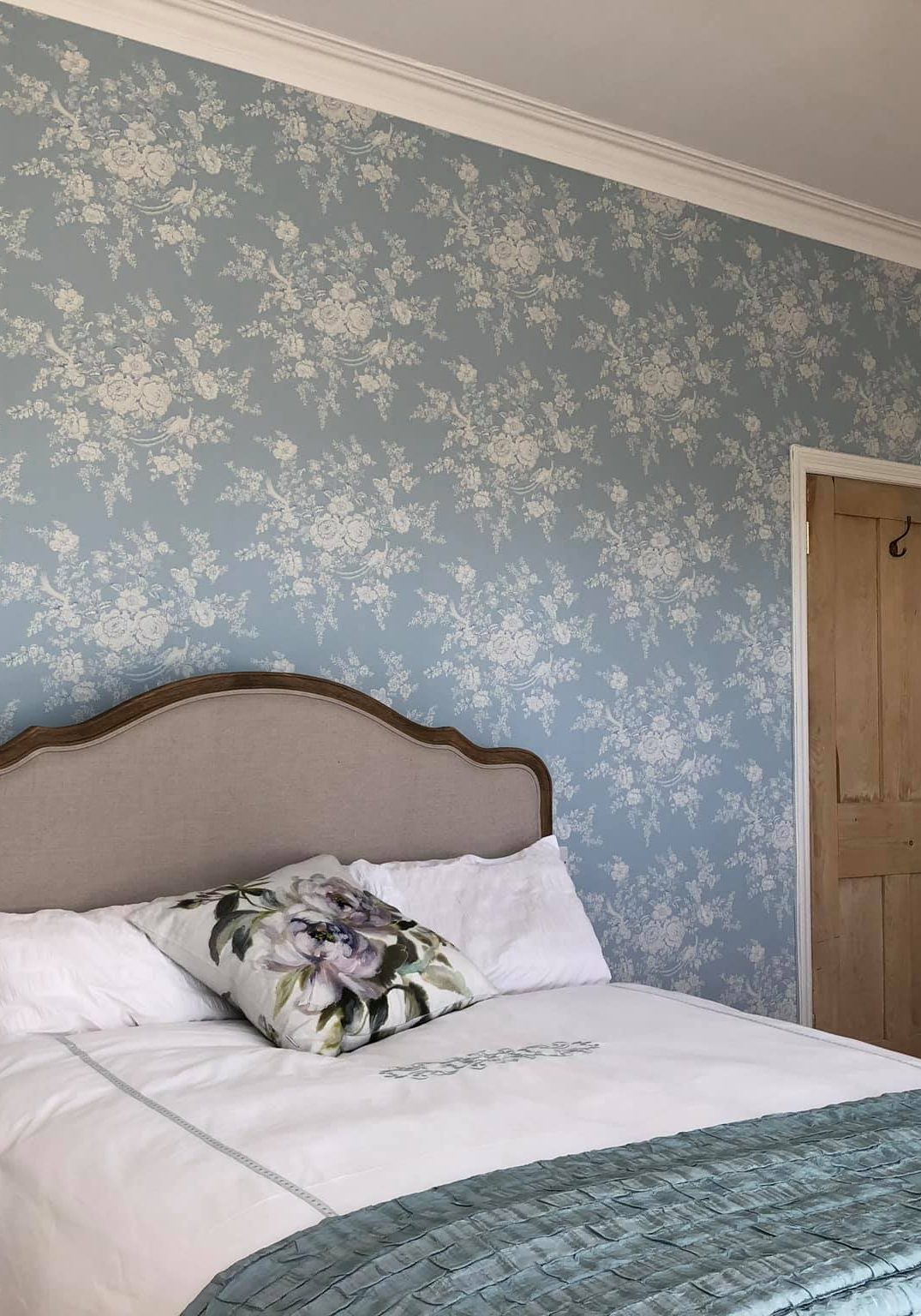 Light blue flowery wallpaper in bedroom